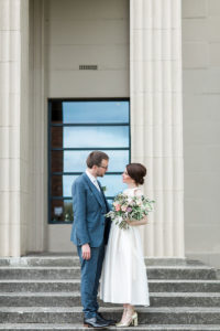 a bride and groom standing outside on the steps of Wylam Brewery