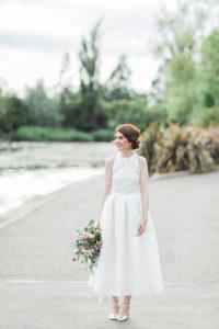 a pretty bride wearing all white and standing outside of Wylam brewery