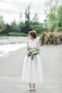 a photo of a bride wearing a two piece wedding outfit outside Wylam brewery